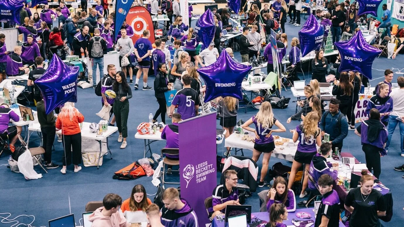 Sports event day at Leeds Beckett University. Lots of students in their sport uniforms, chatting, eating, and having a good time.