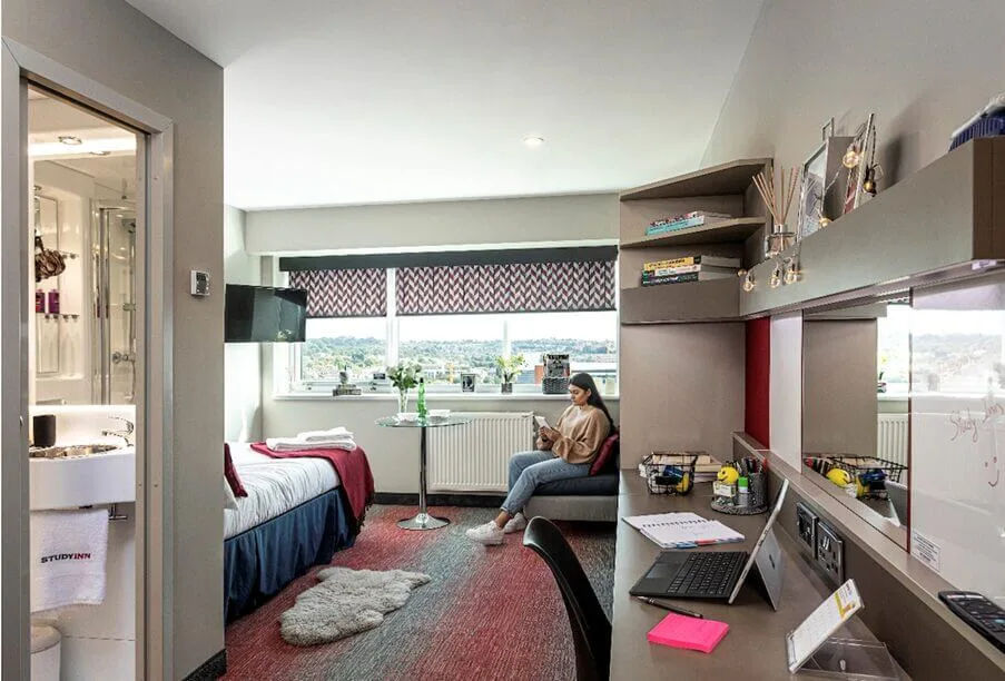 Female student reading a book in the corner of her student accommodation at Study Inn.