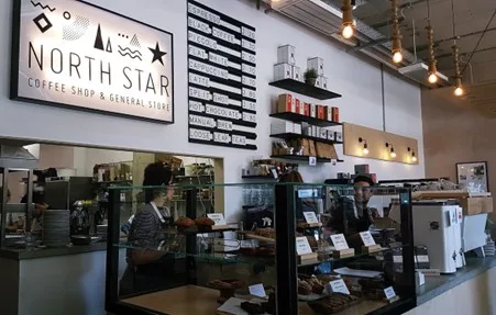 Two baristas working behind the counter at a cafe.