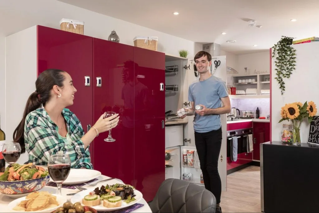 Two students in a modern kitchen at the Study Inn accommodation in Leeds, showcasing the communal living spaces.