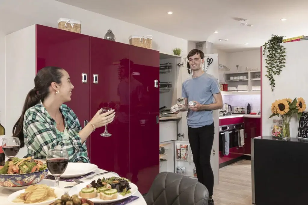 Students cooking and socialising in a modern shared kitchen at Study Inn student accommodation in Leeds.