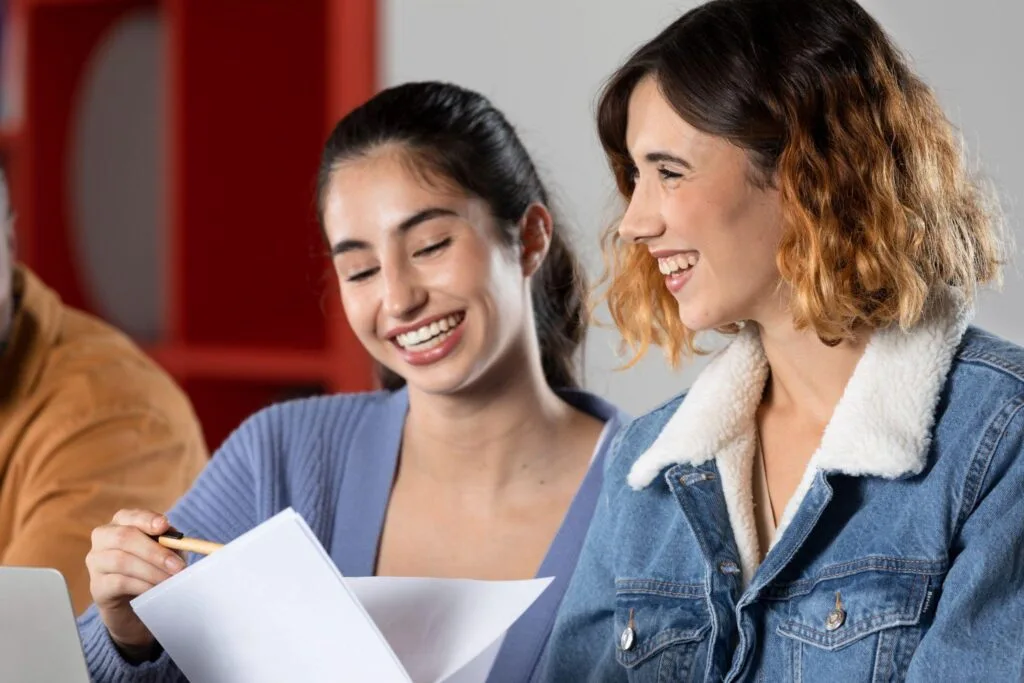 Two students smiling as they review their results together during Clearing