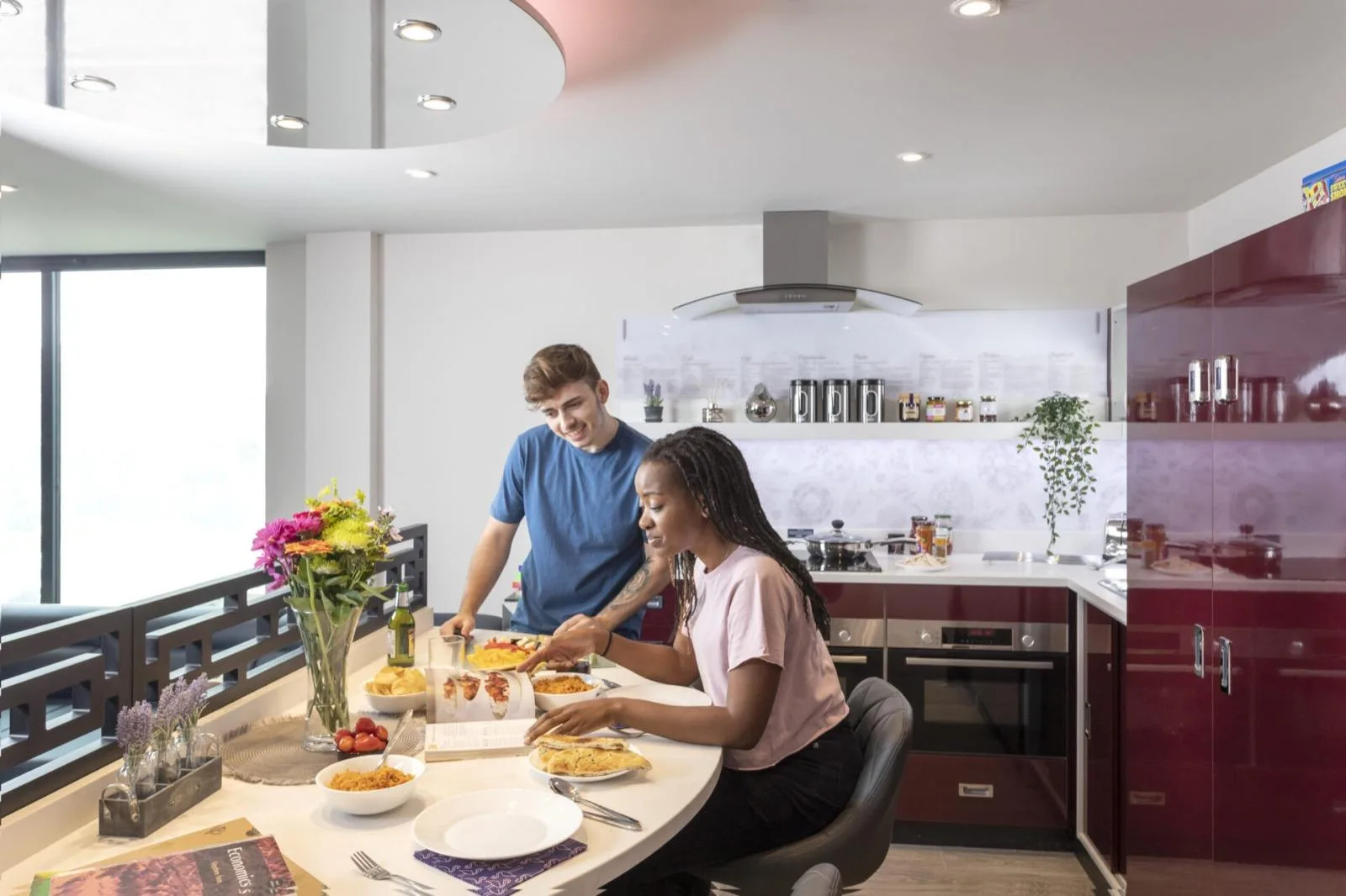 Two residents sharing a meal at the breakfast bar of a Luxe Lounge kitchen at Study Inn Triumph House, Nottingham